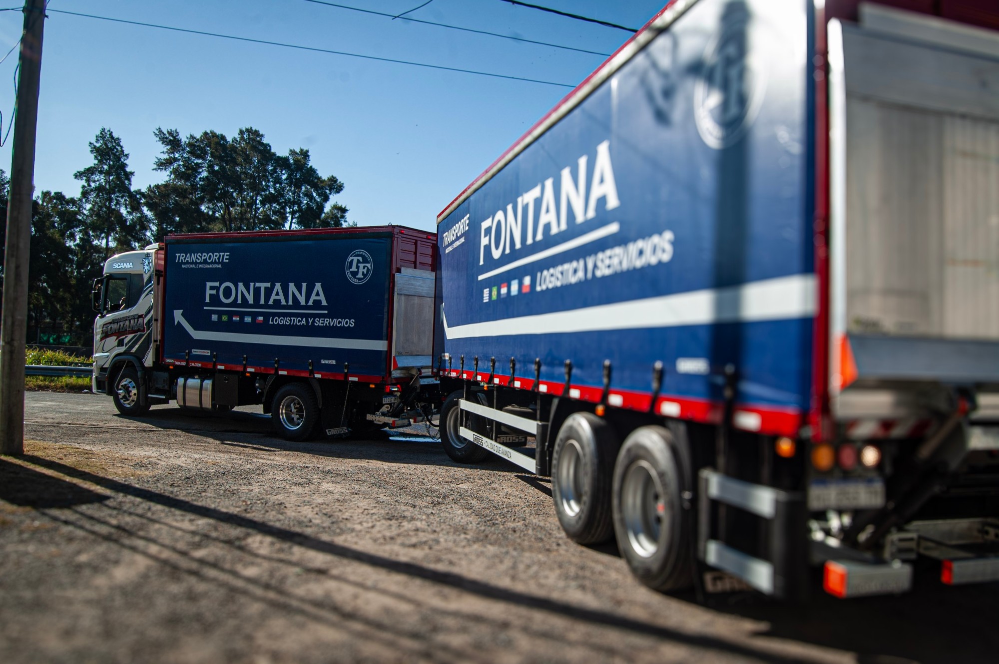 Dos camiones de Transporte Fontana de espaldas, con la gráfica Fontana Logística y Servicios